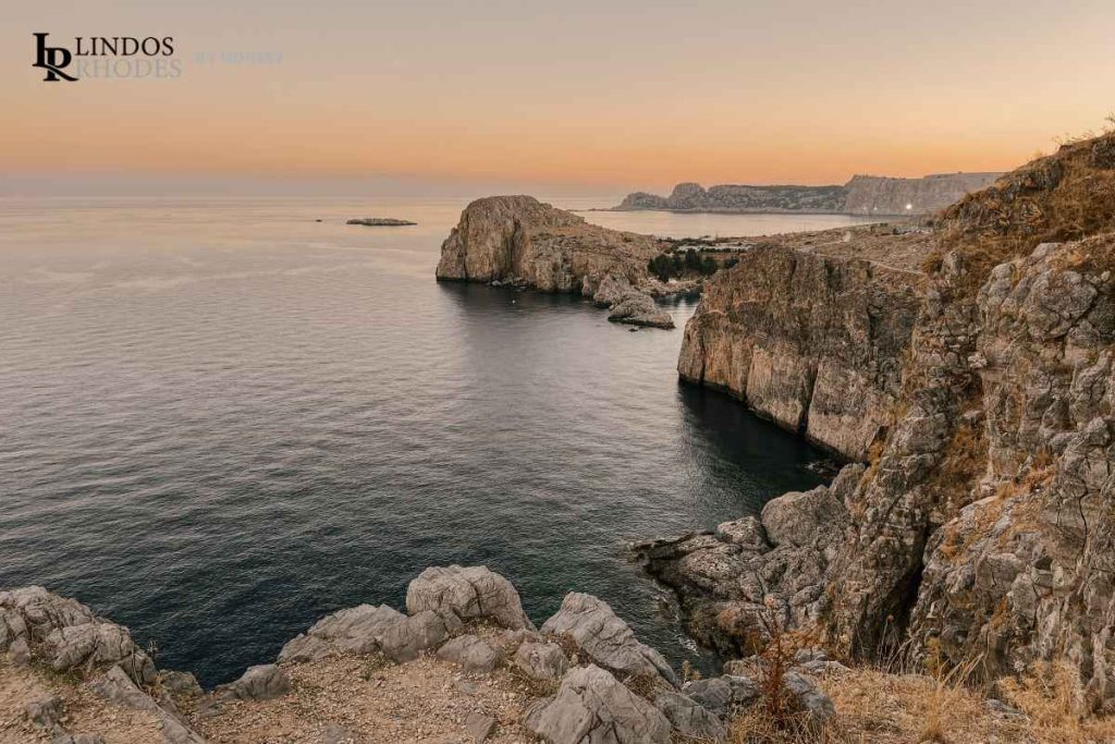Rocky coastline and sea cliffs near Lindos at sunset.